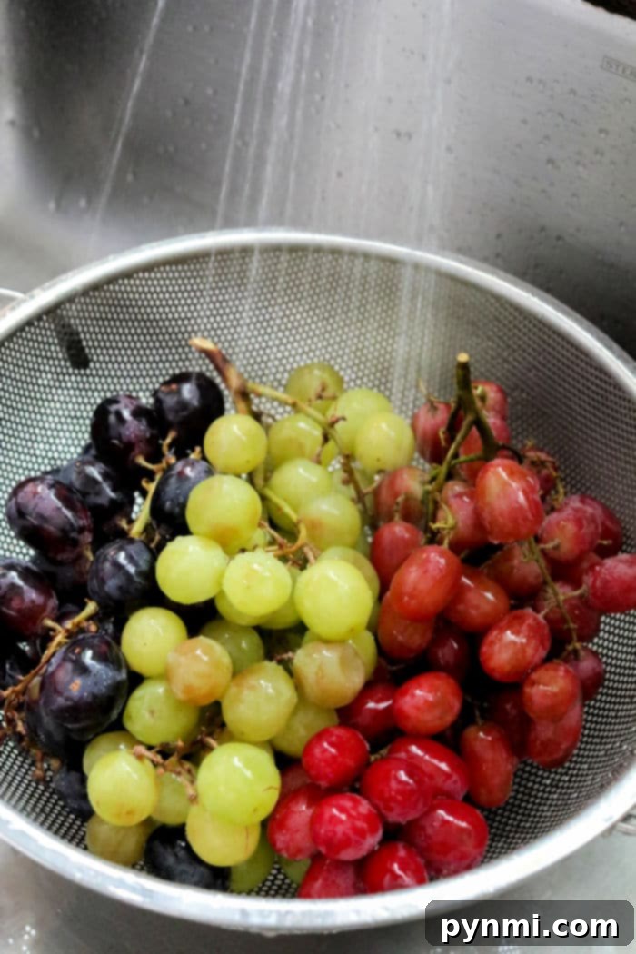 Fresh grapes and crackers on a rustic wooden charcuterie board