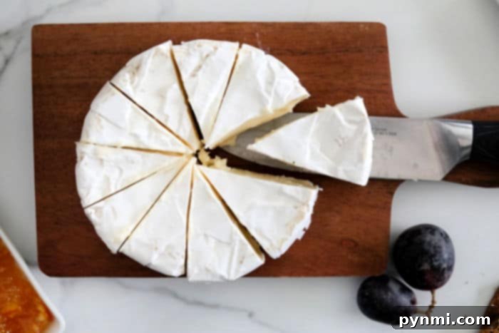 Delicious brie cheese wedge with grapes and crackers, perfect for a charcuterie board