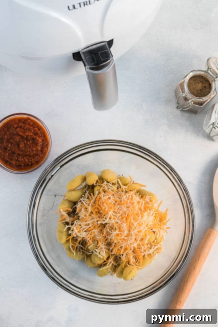 Delicious pizza gnocchi in an air fryer, topped with melted cheese and seasonings.