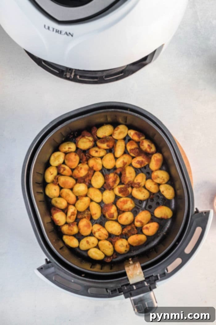 Perfectly golden brown and crispy air-fried gnocchi fresh out of a Ninja Foodi air fryer.