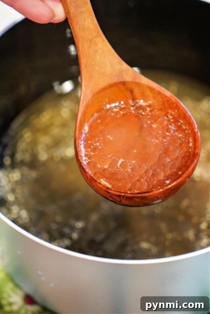 Rich beef bone broth in an Instant Pot, surrounded by fresh vegetables, highlighting the ease of pressure cooking.
