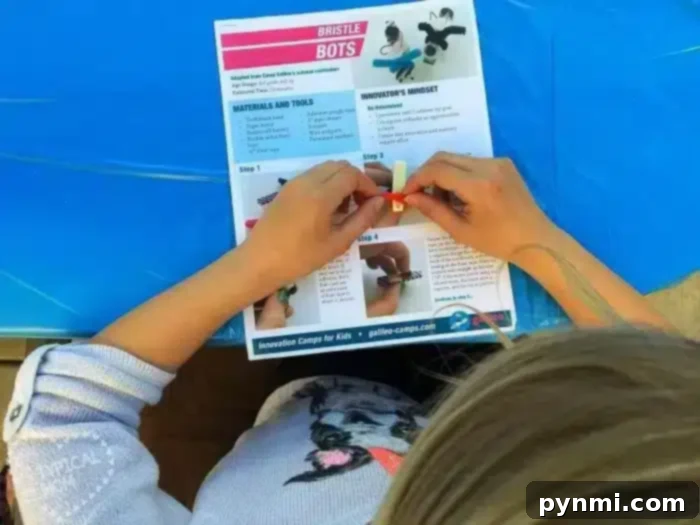 Temecula Summer Bible Adventure 3 A person is assembling a small project using a guide labeled "Bristle Bots." The guide lists materials and steps. The person, wearing a dog-patterned sweater, is working on a blue tablecloth reminiscent of crafts at a Vacation Bible School in Temecula, showcasing the hands-on learning aspect of VBS.