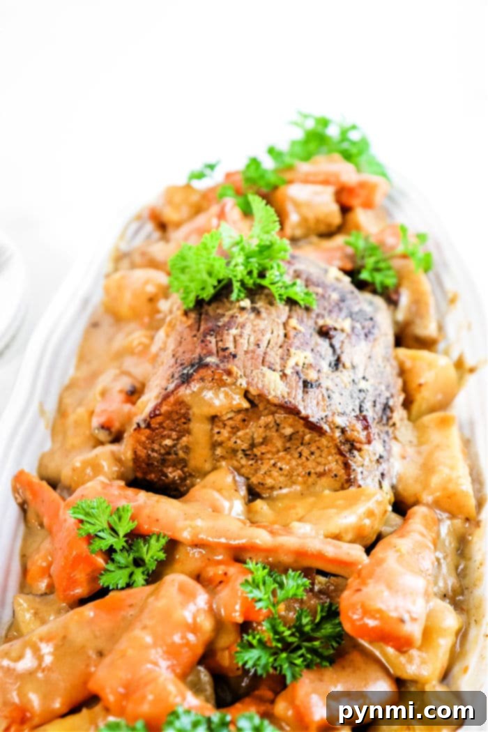 Perfectly cooked Sirloin Tip Roast in a slow cooker, served with tender carrots, potatoes, and savory gravy.