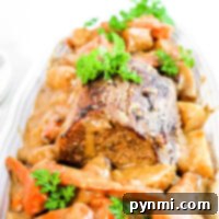A plate of tender sirloin tip roast, slow-cooked to perfection with carrots, potatoes, and a parsley garnish, all generously covered in savory gravy.