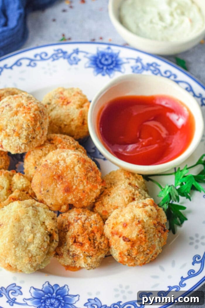 Crispy air fryer mashed potato balls stacked on a plate, garnished with fresh parsley.