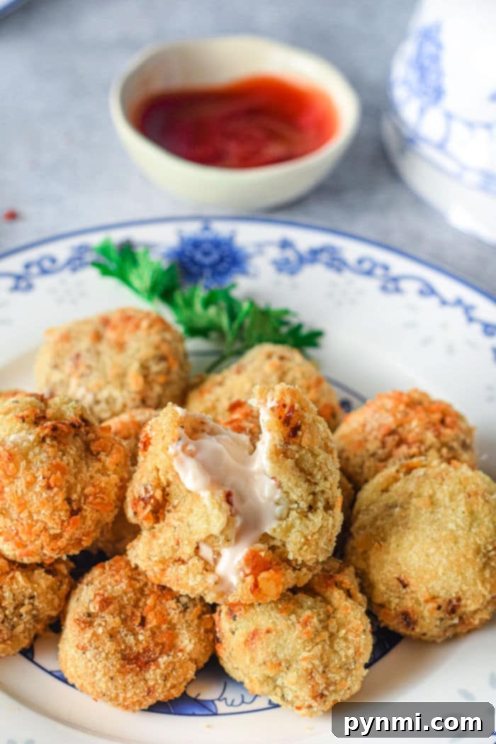 A bowl filled with air fryer mashed potato balls, beautifully golden and garnished with fresh herbs, ready for serving.