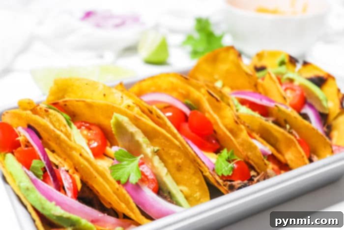 Mouthwatering Slow Cooker Taco Meat 9 Freshly prepared crockpot tacos with a variety of colorful toppings laid out on a serving board.
