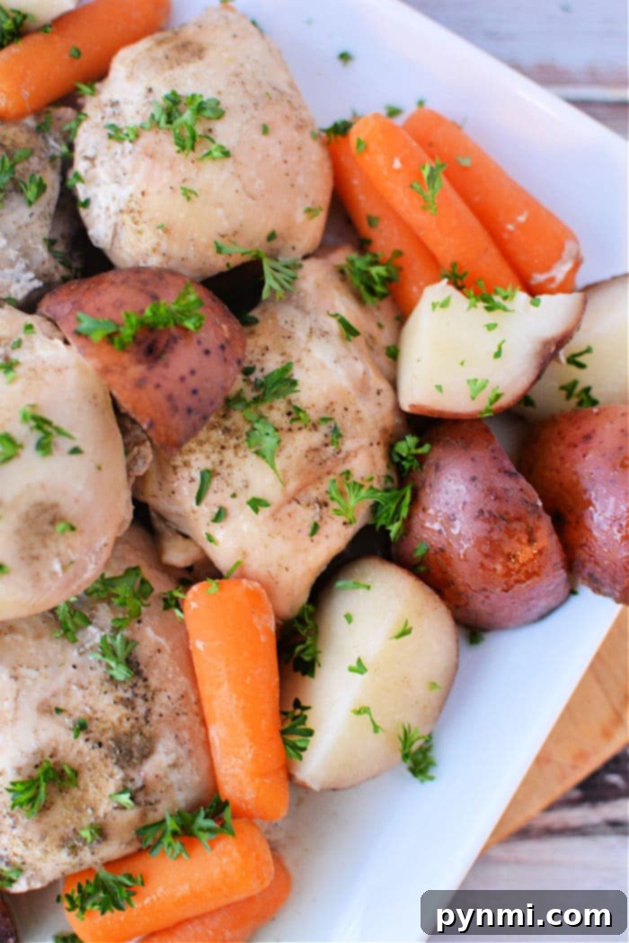 Effortless Slow Cooker Chicken Thighs and Potatoes 2 Slow Cooker Chicken Thighs and Potatoes: A hearty, flavorful one-pot meal featuring tender chicken, roasted red potatoes, and carrots, ready to be served from the crockpot.