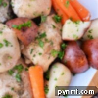 A slow cooker delight, this dish features tender chicken thighs with roasted potatoes and carrots, all garnished with chopped parsley in a white bowl.