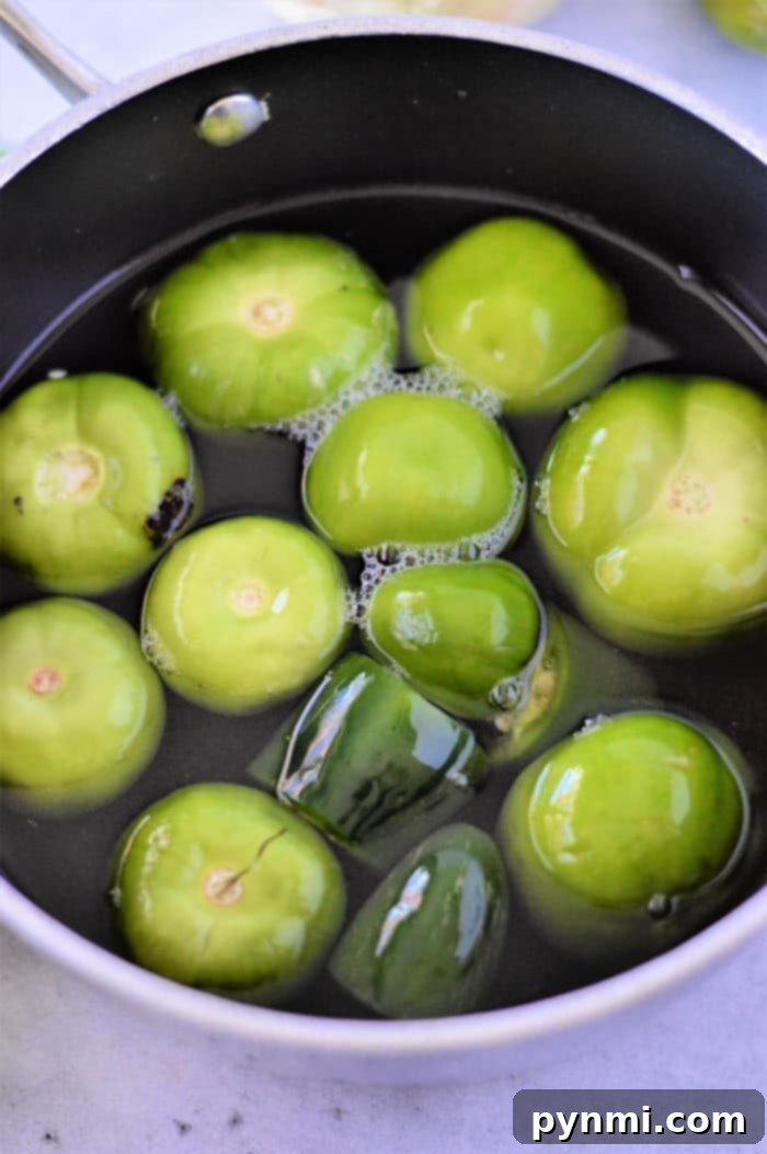 Cleaned tomatillos without husks, ready to be cooked, arranged on a cutting board, highlighting the simple preparation process.