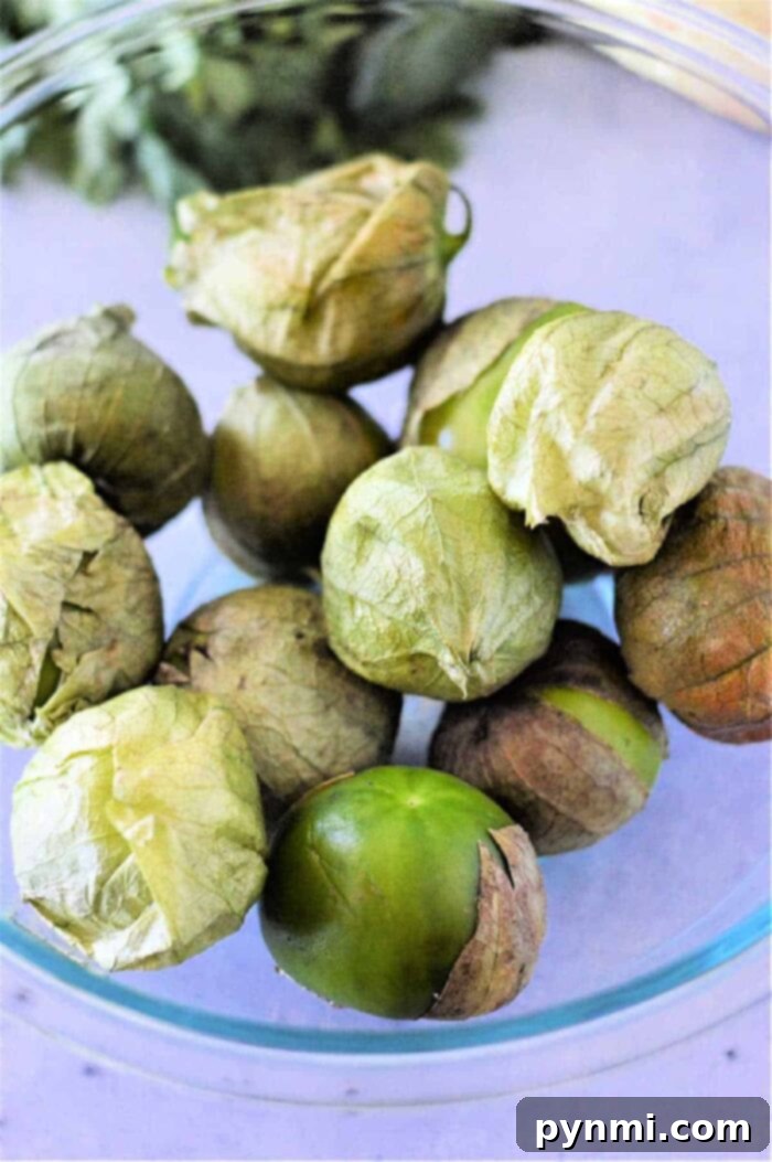 A cutting board with cooked and sliced tomatillos, illustrating their tender texture after boiling, ready for various culinary applications.