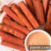 A plate of crispy Spam Fries served with a small bowl of creamy dipping sauce, garnished with chopped herbs.