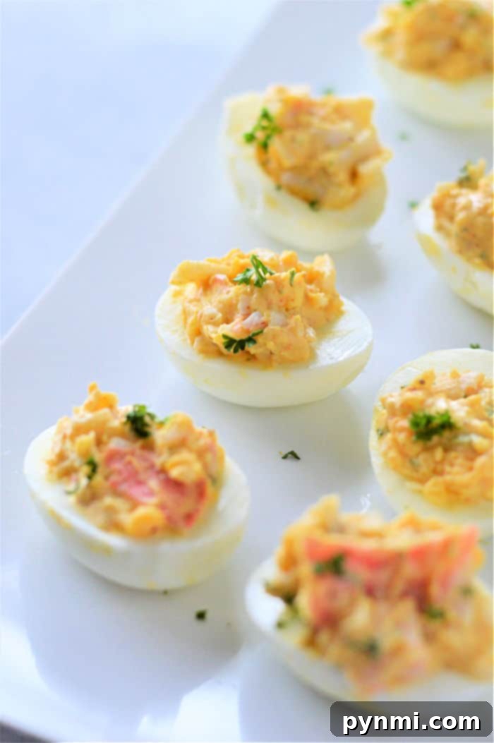 Decadent Crab Deviled Eggs 4 Beautifully arranged crab stuffed eggs on a serving platter, ready for guests.