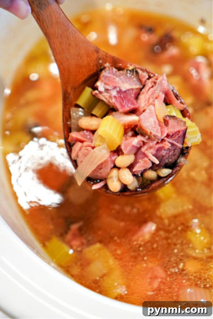 Unlocking the Flavor of Ham Hocks 6 A hearty bowl of Slow Cooker Ham Hocks and Beans, garnished with fresh herbs, ready to be enjoyed as a comforting meal.