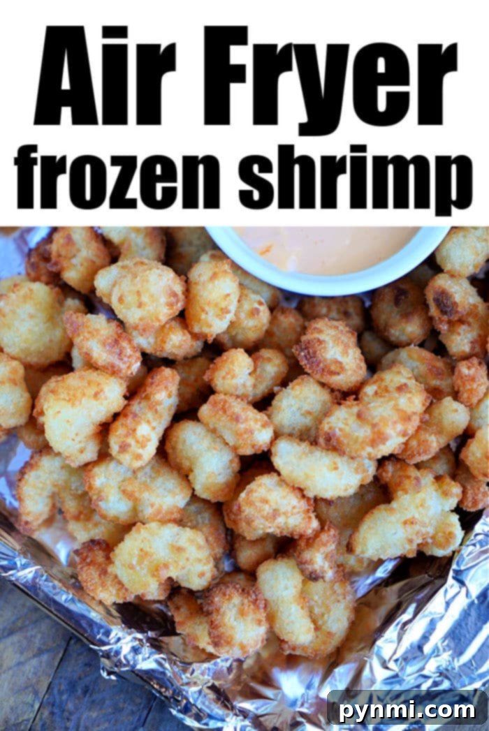 Crispy Air Fryer Popcorn Shrimp 5 A pile of crispy frozen popcorn shrimp sits on foil, topped with a small bowl of dipping sauce. The text above reads Air Fryer frozen shrimp.