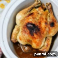 A frozen whole chicken rests, perfectly seasoned with pepper, in a Crockpot. It's nestled in a pool of savory juices, while a hint of yellow floral cloth adds a touch of charm to the scene.