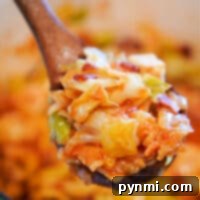 A close-up of a wooden spoon holding cooked swamp cabbage and noodles in a pot captures the essence of comfort food.