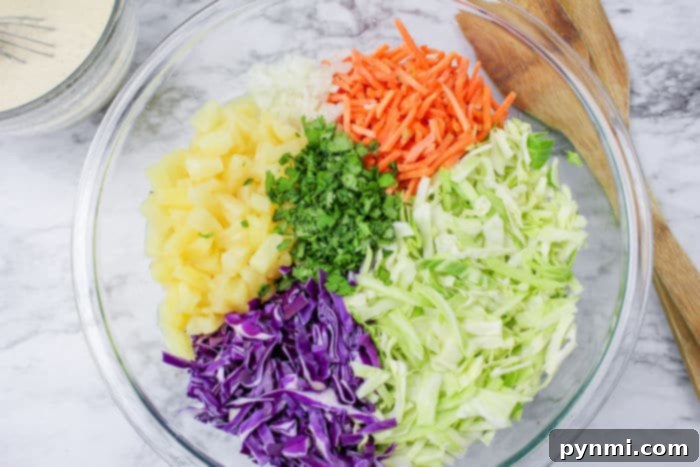 A generous serving of pineapple coleslaw, showcasing the colorful mix of red and green cabbage, carrots, and pineapple pieces, ready to be enjoyed.