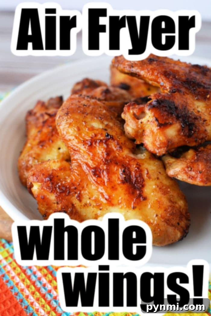 A vibrant overhead shot of whole chicken wings in an air fryer basket, ready to be served.