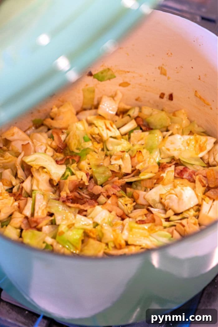 Hearty fried cabbage in a Dutch oven with smoked sausage