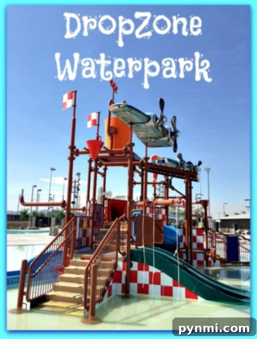 DropZone Perris Water Park: Is It Worth the Splash 2 An aquatic play structure with several water slides and climbing features at Perris Water Park's DropZone Waterpark. The structure includes red and white checkered elements and a blue airplane model at the top. The text