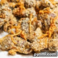 Close-up of crispy, golden brown fried gizzards with a breaded coating on a white plate, showcasing perfectly cooked air fryer chicken gizzards.