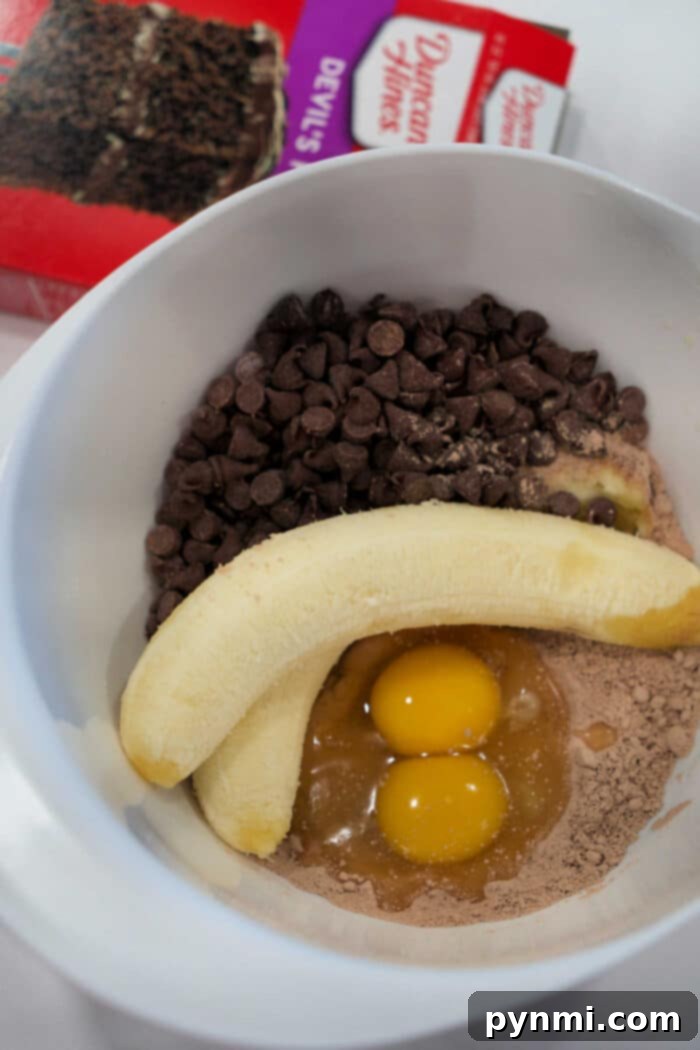 Ingredients for chocolate banana bread: eggs, banana, chocolate chips, and cake mix.