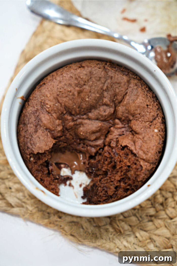Lava Cake Bliss: Single-Serving Indulgence 6 Chocolate lava cake in a ramekin with a spoonful missing.