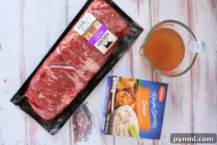 Raw beef steak in packaging, a measuring cup of broth, and a box of onion soup mix on a white wooden surface—perfect ingredients for an easy Slow Cooker Skirt Steak recipe.