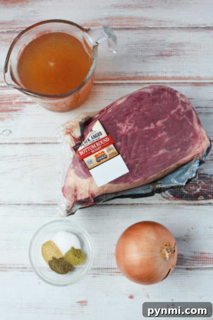 A raw beef bottom round roast, onion, spices, and beef broth in containers are arranged on a white wooden surface—perfect for your next slow cooker meal.