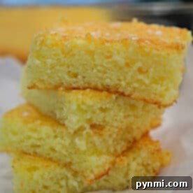 A perfectly baked square of lemon angel food cake, garnished with a light dusting of powdered sugar, ready to be served and enjoyed as a delightful dessert.