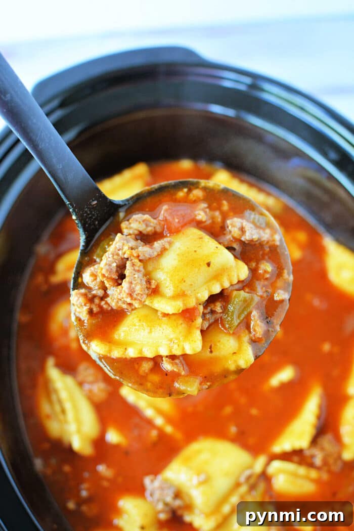 Slow-Cooker Lasagna Soup Recipe for Comforting Weeknight Meals 2 A ladle holds ravioli, ground beef, and tomato sauce over a Crockpot filled with the same mixture, creating a comforting Crockpot Lasagna Soup.