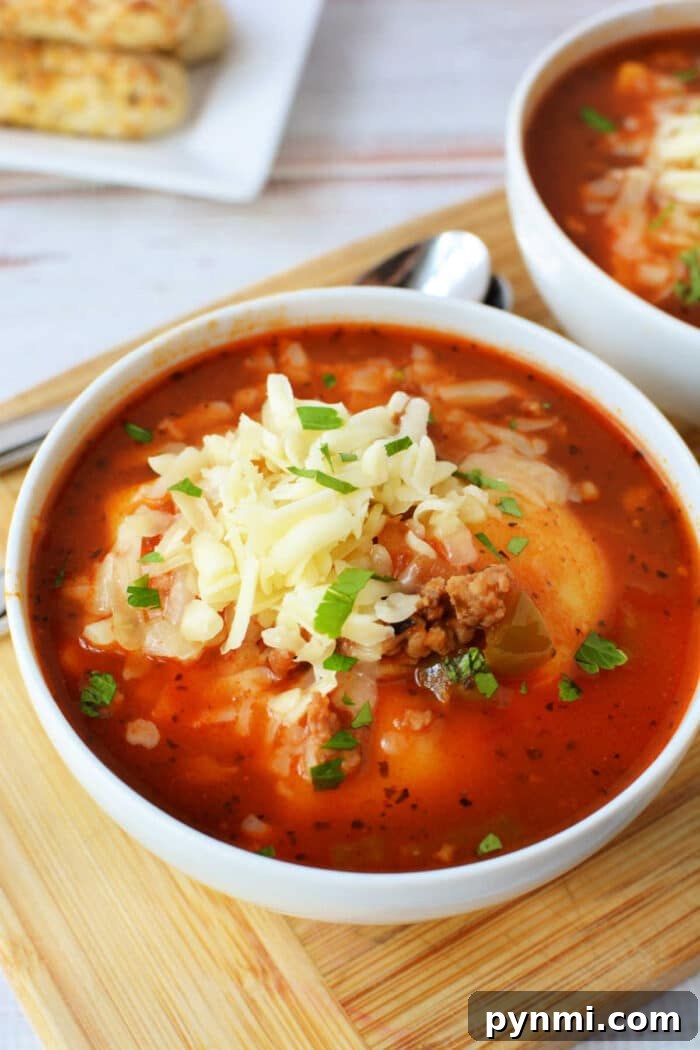 Slow-Cooker Lasagna Soup Recipe for Comforting Weeknight Meals 6 A bowl of hearty Slow Cooker Lasagna Soup topped with shredded cheese and chopped herbs sits on a wooden board.
