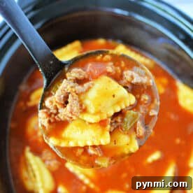 Slow-Cooker Lasagna Soup Recipe for Comforting Weeknight Meals 7 A ladle holds ravioli, ground beef, and tomato sauce over a Crockpot filled with the same mixture, creating a comforting Crockpot Lasagna Soup.