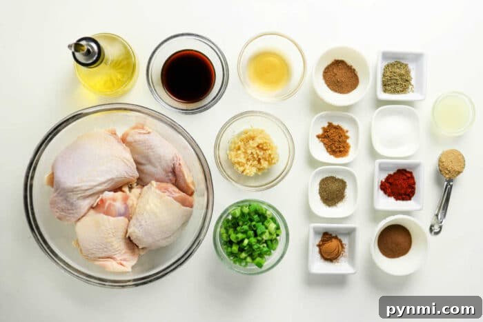 Oven-Baked Jerk Chicken Recipe – Crispy, Flavorful & Authentic 3 Raw chicken thighs, chopped green onions, minced garlic, sauces, oil, and various spices arranged on a white surface—perfect for preparing flavorful Oven Jerk Chicken.
