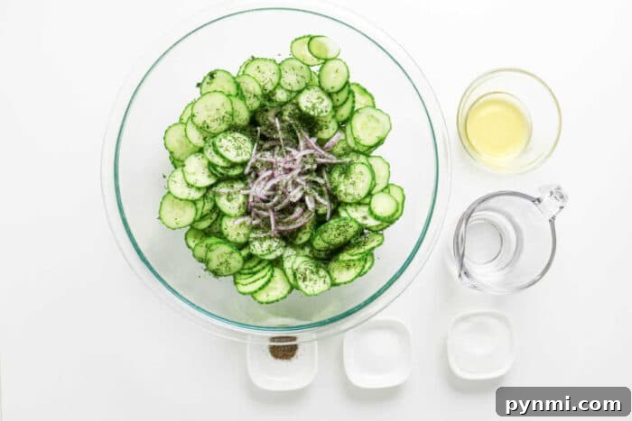 Crisp Cucumber Dill Salad with Creamy Yogurt Dressing 4 Glass bowl with sliced cucumbers, onions, and fresh dill, creating a crisp cucumber salad, surrounded by vinegar, water, salt, sugar, and pepper.