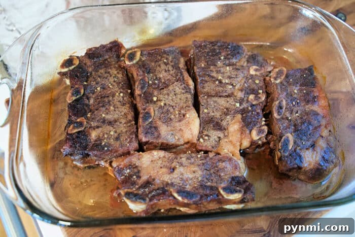 Flavorful Grilled Flanken Short Ribs Recipe for Tender Results 4 Five cooked beef short ribs in a glass baking dish, seasoned and ready to serve.