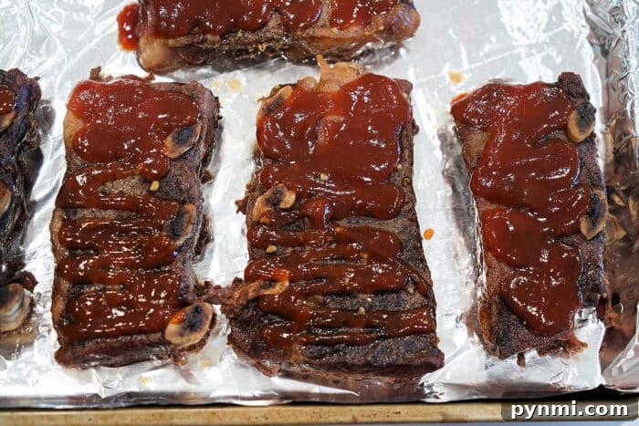 Flavorful Grilled Flanken Short Ribs Recipe for Tender Results 5 Three pieces of barbecued Flanken Short Ribs topped with sauce on a foil-lined baking sheet.