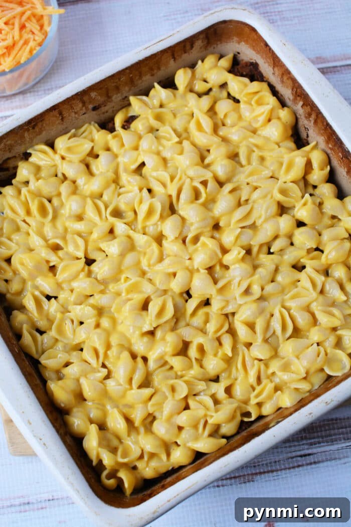 Mac and Cheese Meatloaf Casserole Recipe for Comfort Dinner 5 A baking dish filled with creamy mac and cheese made with shell pasta, ready to be baked into a delicious casserole.