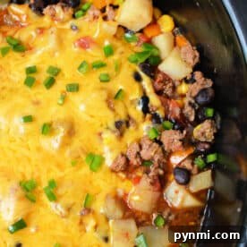 Enjoy this hearty Cowboy Casserole Crockpot dish—cheesy ground beef, potatoes, black beans, corn, and green onions all slow-cooked to perfection.