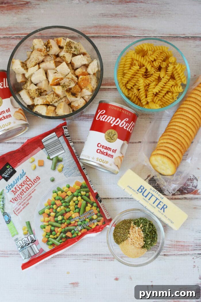 Cheesy Ritz Chicken Casserole with Crispy Cracker Topping 3 Cubed chicken, rotini pasta, canned soup, mixed veggies, crackers, butter, and seasonings are arranged on the table—everything you need to make a classic Ritz Chicken Casserole.